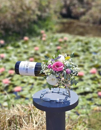 סידור פרחים ומעמד לבקבוק בצבע כסף עליכם לבחור יין שברצונכם