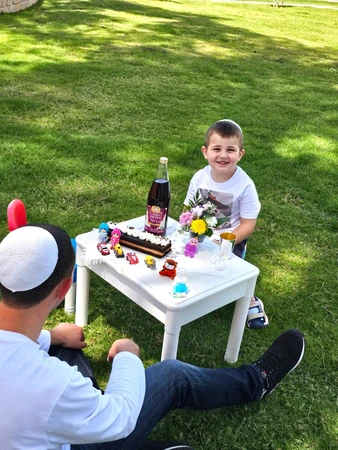 אב שבת הכולל בקבוק יין תירוש כוס קידוש שתי נרות עוגת שוקולד סידור פרחים ו25 צעצועים לבחירה