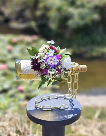 סידור פרחים ומעמד לבקבוק בצבע זהב עליכם לבחור יין שברצונכם